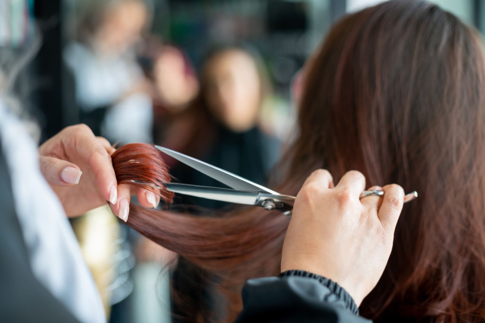 Close up of unrecognizable hairdresser cutting a female customerâs hair - Small business concepts